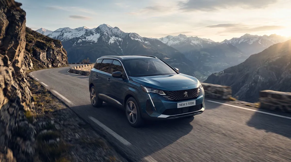Peugeot 5008 yedi kişilik SUV, geniş aile kullanımına uygun yapısıyla dağ manzaralı yolda ilerliyor.