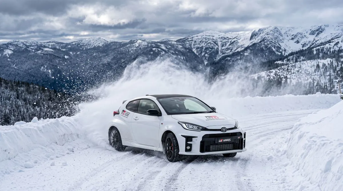 Karlı virajlı dağ yolunda ilerleyen Toyota GR Yaris, ralli teknolojisini günlük kullanıma taşıyan sportif hatchback model.